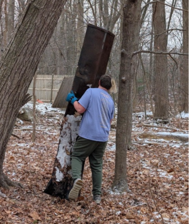 A person carrying a large metal barrel in the woods
AI-generated content may be incorrect.